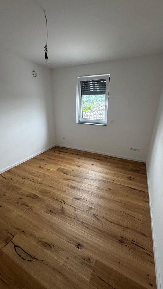 Sanierter Raum mit neuem Holzboden und Fenster